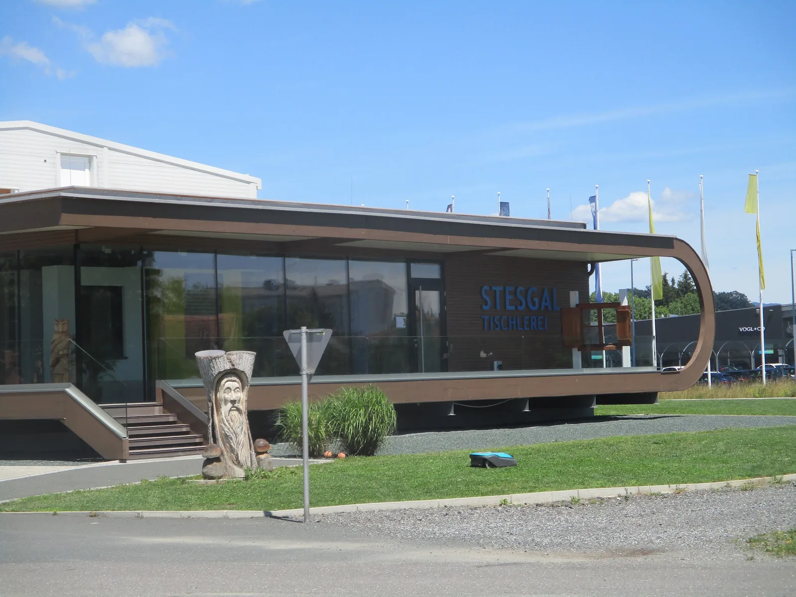 Schauraum von STESGAL Tischlerei Fenster in Oberwart bei Tag, mit Holzskulptur vor dem Eingang