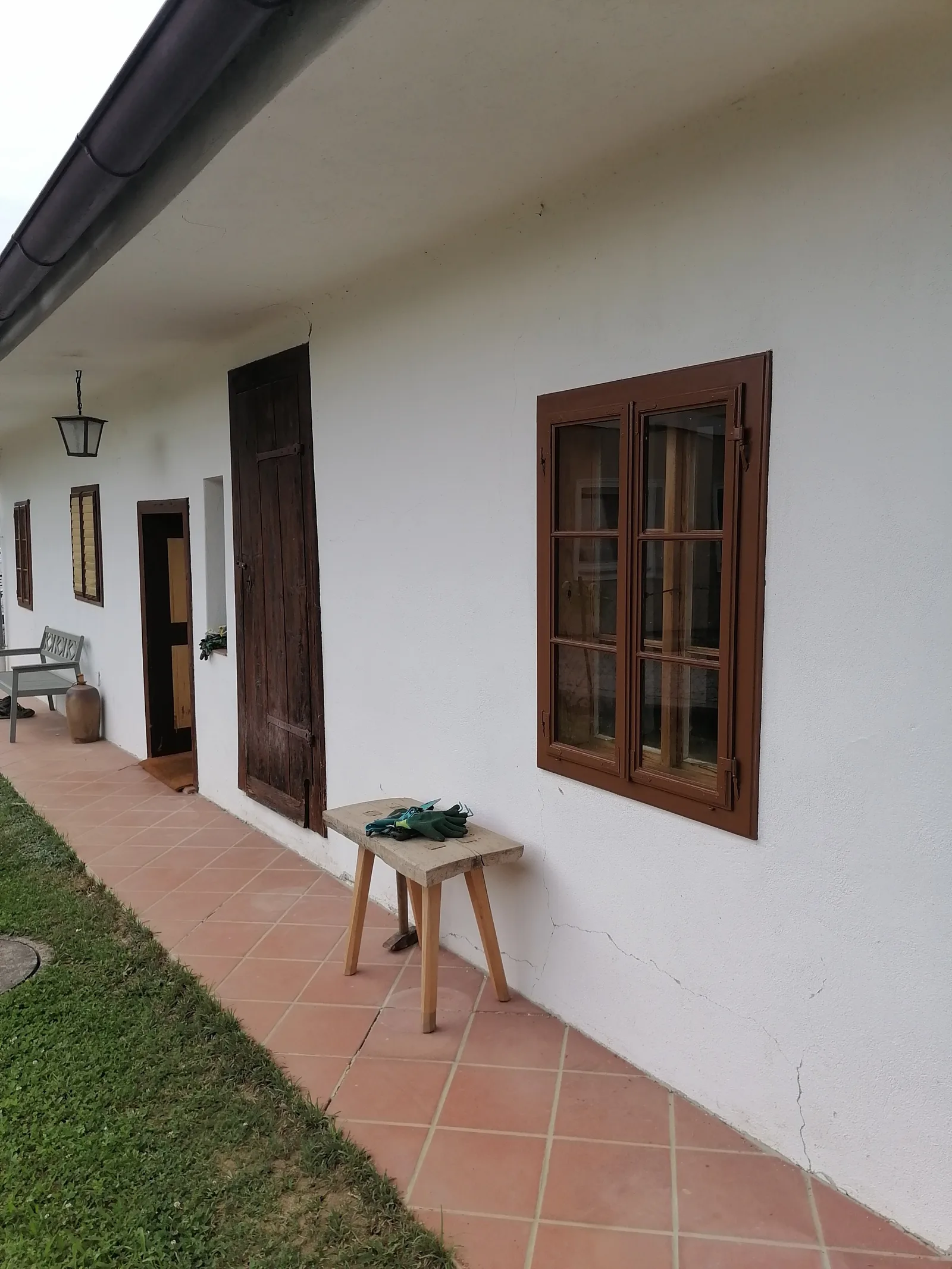 Saniertes braunes Holzfenster an einem weißen Streckhof