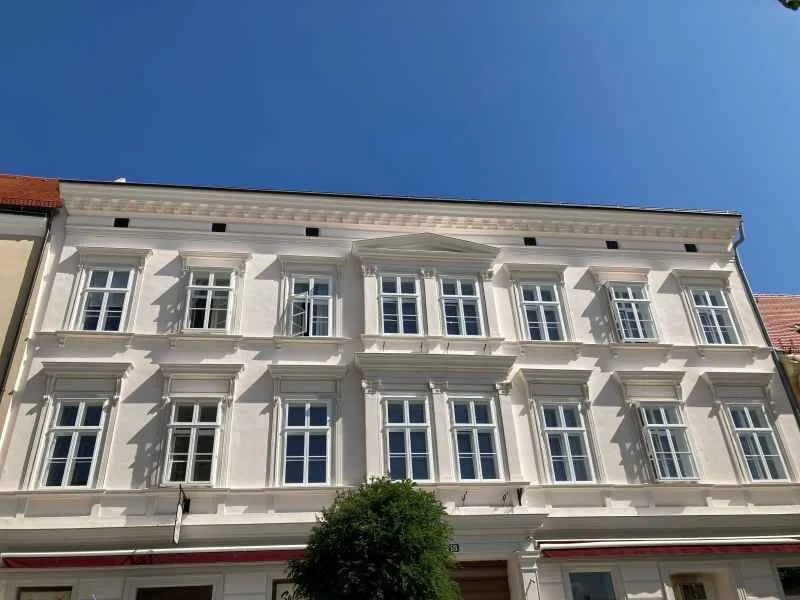 Weiße Gründerzeitfassade mit vielen Sprossenfenstern